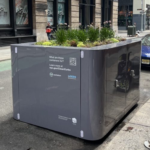 Clean Curbs bin box. Waste container in curb lane with plants on top of it
