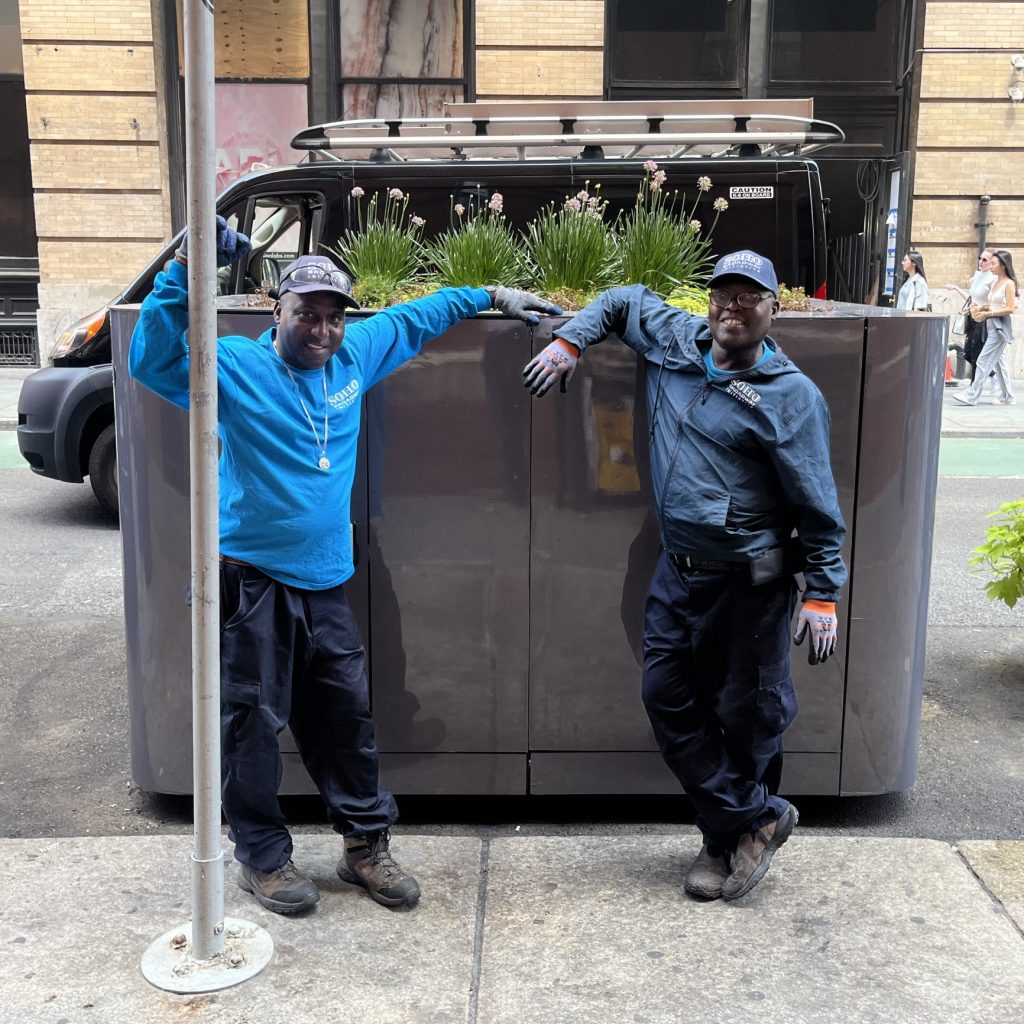 Clean Team Field Supervisors posing in front of SoHo Broadway Clean Curbs Prototype Waste Container