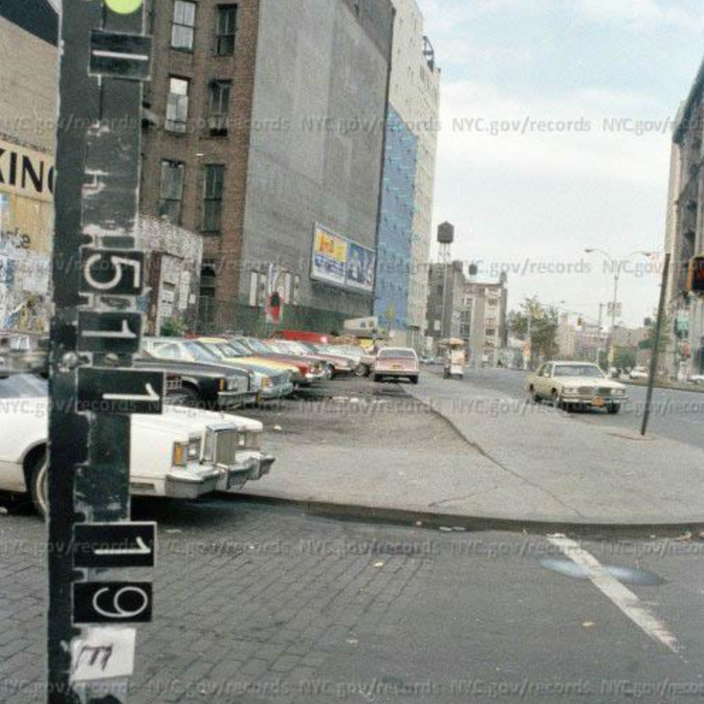 A photo from 1980 shows older cars parked in a lot and on the sidewalk on Houston St