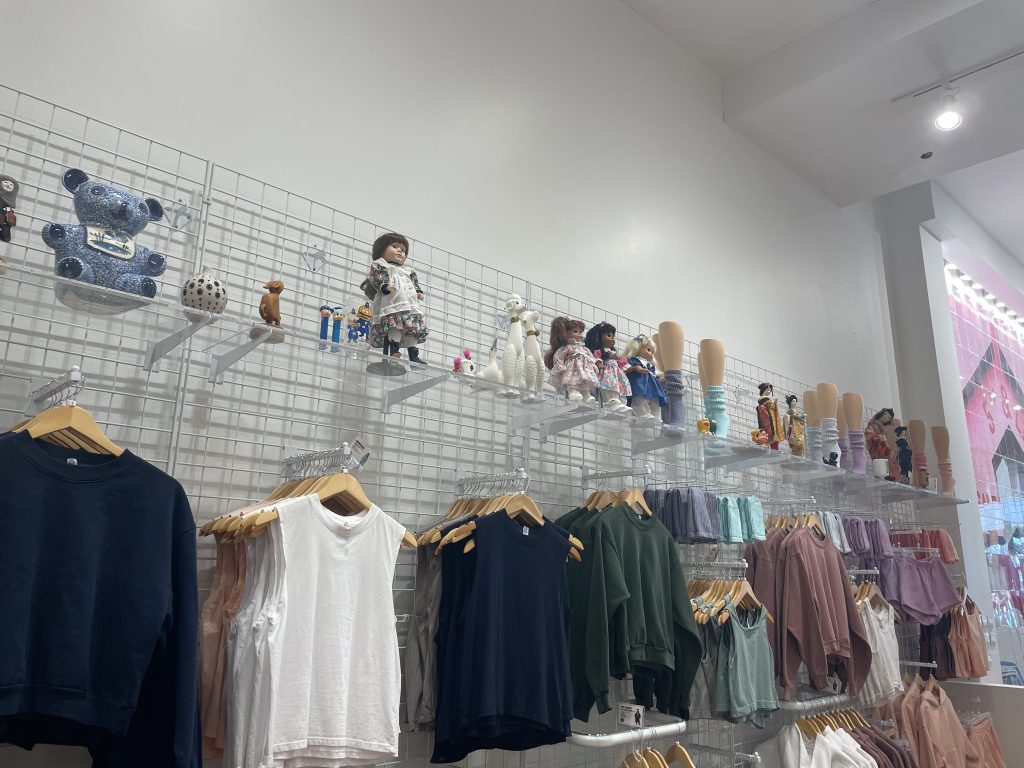 Vintage dolls and other tchotchkes are displayed alongside new clothes. 