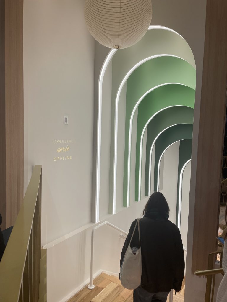 Stairs going down with green archways and a light fixture