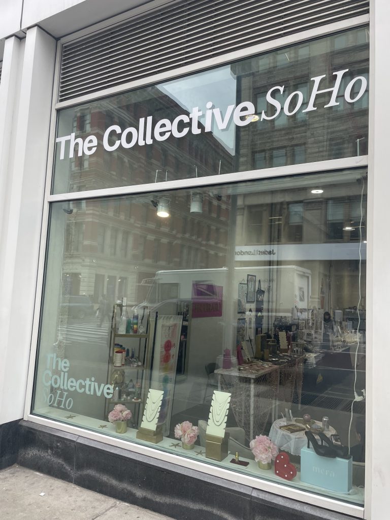 A store window with "The Collective SoHo" written in white on it
