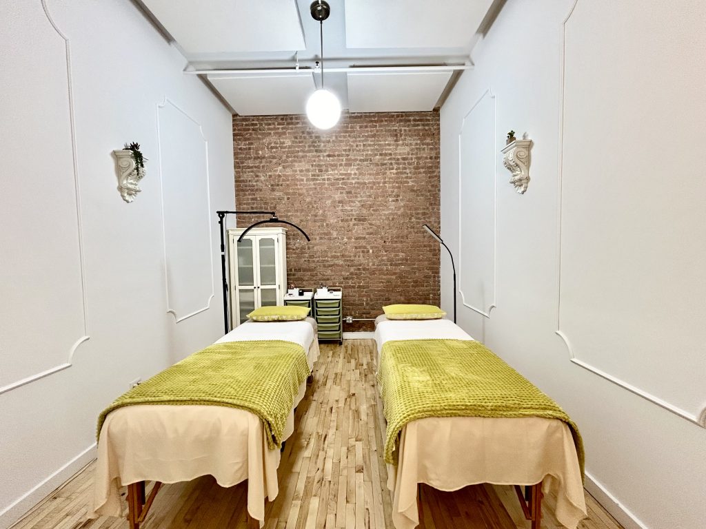 two spa beds in a small room with green blankets